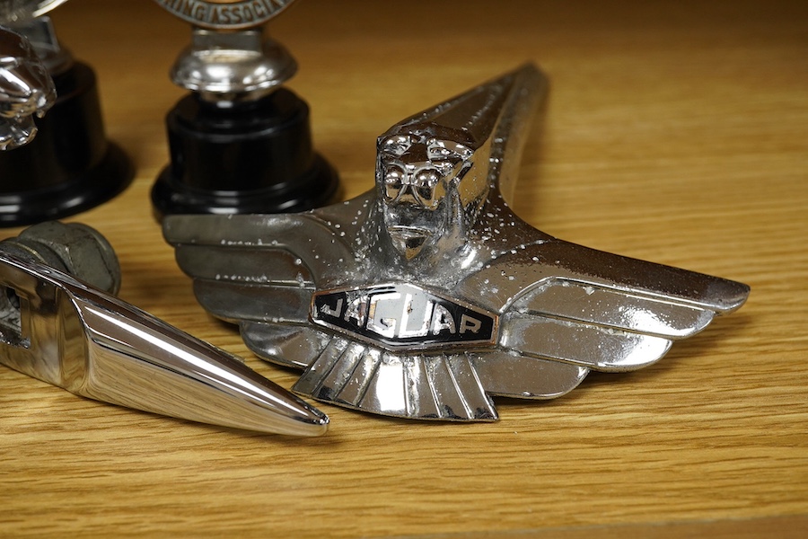 Three Jaguar car mascots in the form of the leaping Jaguar, together with an early Jaguar bonnet decoration, a ‘Royal Automobile Club Associate’ radiator cap mascot with enamel Union flag to the centre, and a ‘Civil Serv